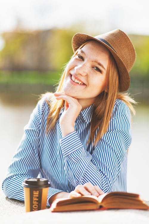 Selected Focus Photo of Woman Holding Book on White Table