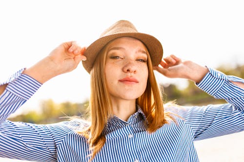 бесплатная Женщина в коричневой шляпе и синей полосатой классической рубашке Стоковое фото