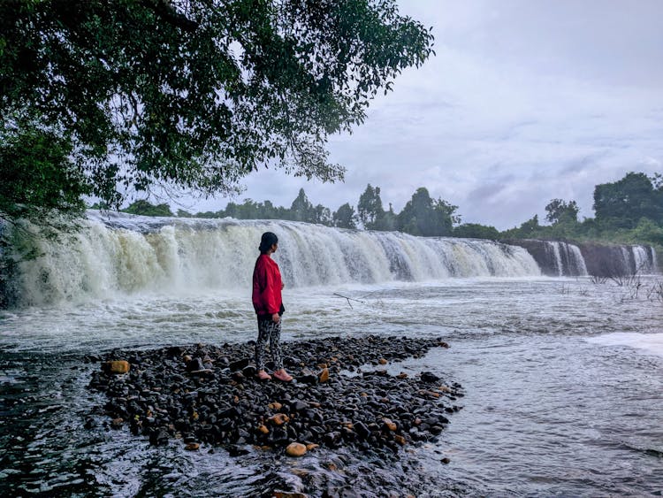 Woman Standing On Wet Rocks