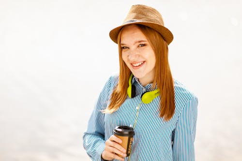 бесплатная Улыбающаяся женщина в шляпе с чашкой Стоковое фото