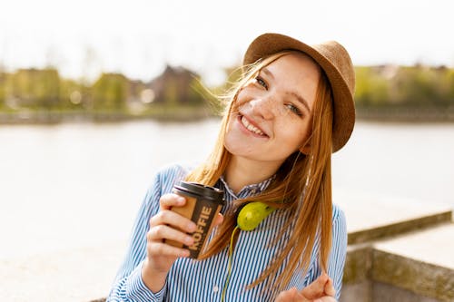 写真を撮りながらカップを保持している女性