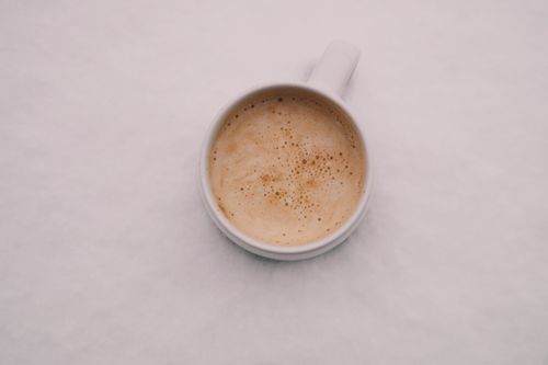 Free Aerial view of a creamy cappuccino in a white mug, creating a calming coffee moment. Stock Photo