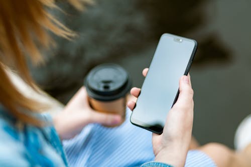 無料 黒い画面で黒いスマートフォンを保持している女性 写真素材