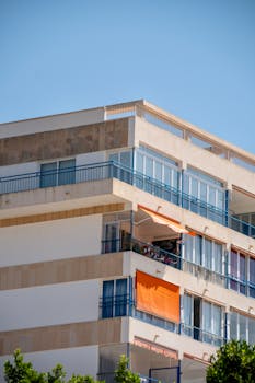 A contemporary apartment building with balconies under a clear blue sky.