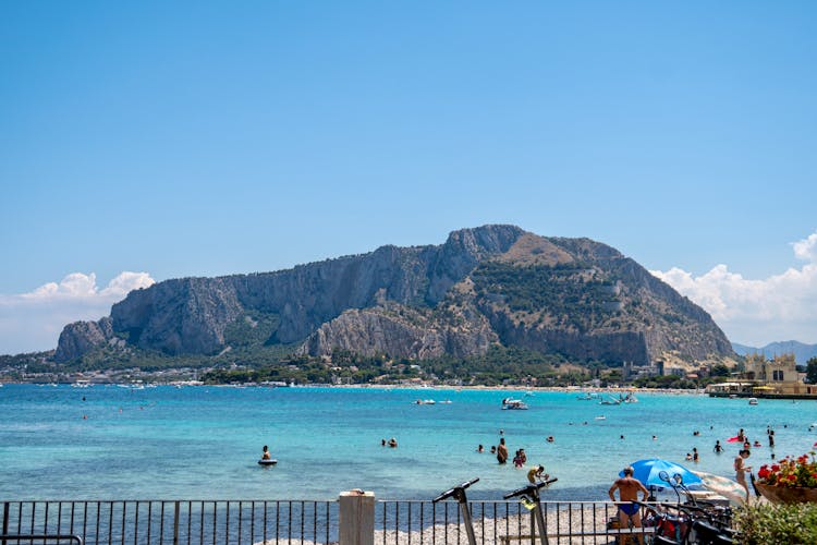 People On Swimming On The Beach Near The Mountain