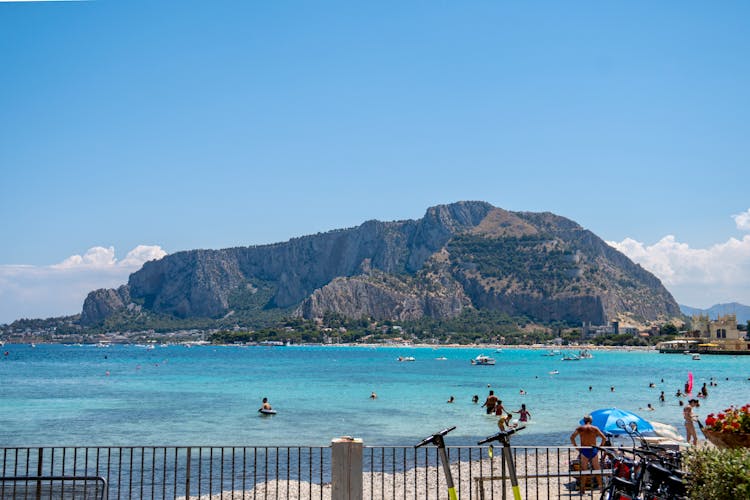 People On Swimming On The Beach Near The Mountain