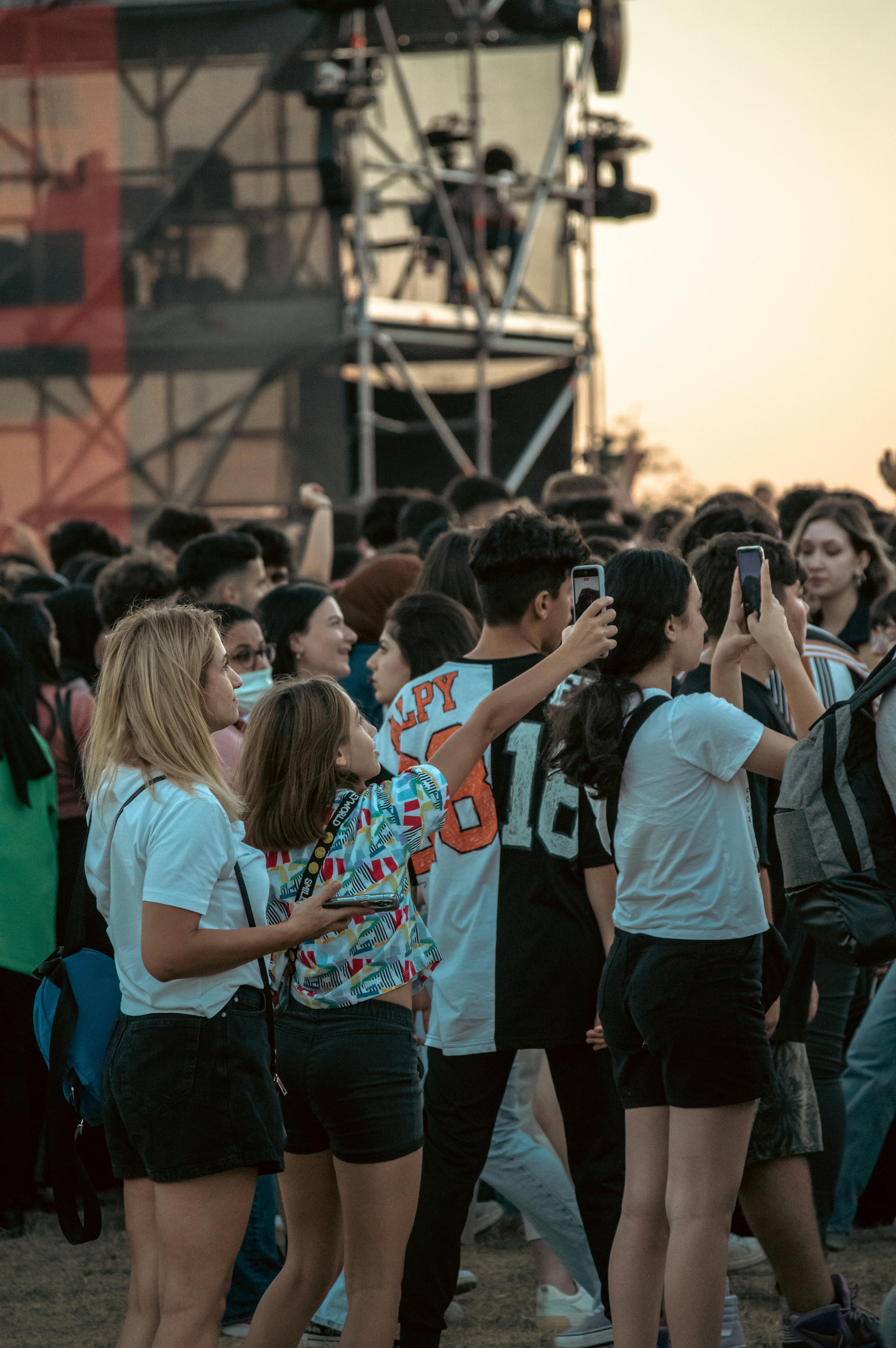 A lively crowd enjoys a concert in Istanbul, taking photos and videos.