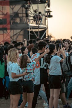 A lively crowd enjoys a concert in Istanbul, taking photos and videos.