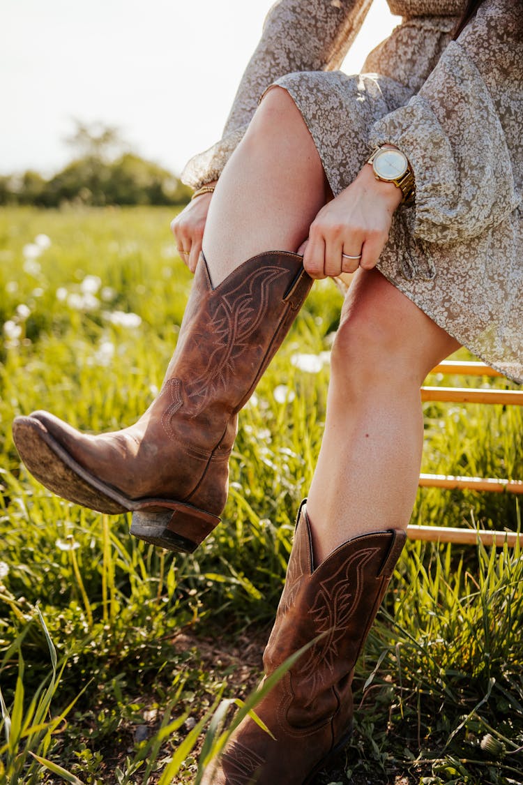 Woman Putting On Leather Cowboy Boots 