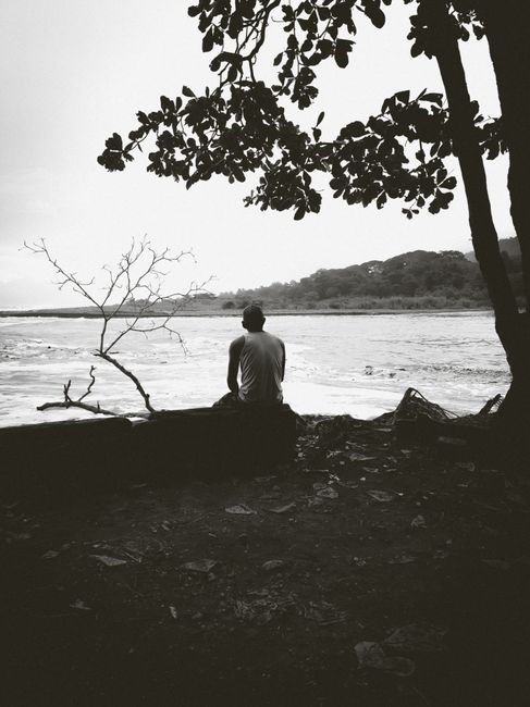 Silhouette of a man gazing at a tranquil river in Costa Rica.