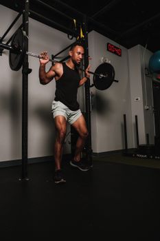 Adult man lifting weights with barbell in a gym setting, showcasing strength and fitness.