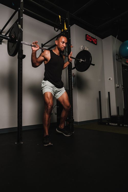 Free Adult man lifting weights with barbell in a gym setting, showcasing strength and fitness. Stock Photo