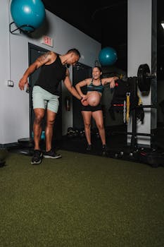 Smiling pregnant couple enjoying a workout session in the gym, promoting fitness and wellness during pregnancy.