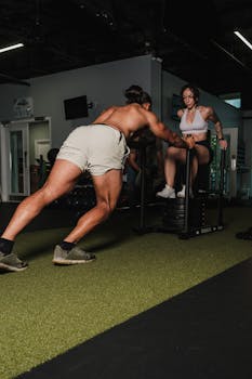 A couple engaged in an intense workout session indoors, emphasizing fitness and teamwork.