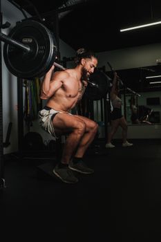 A shirtless man lifts weights during an intense gym workout, showcasing strength and fitness.