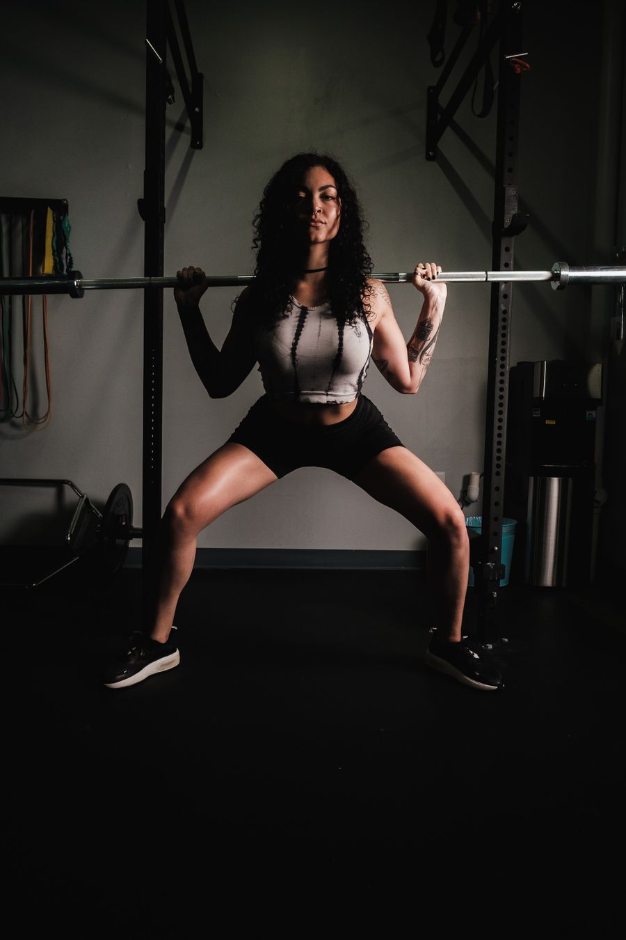 Athlete squatting with a barbell in a low-lit training studio — photo by Airam Dato-on on Pexels