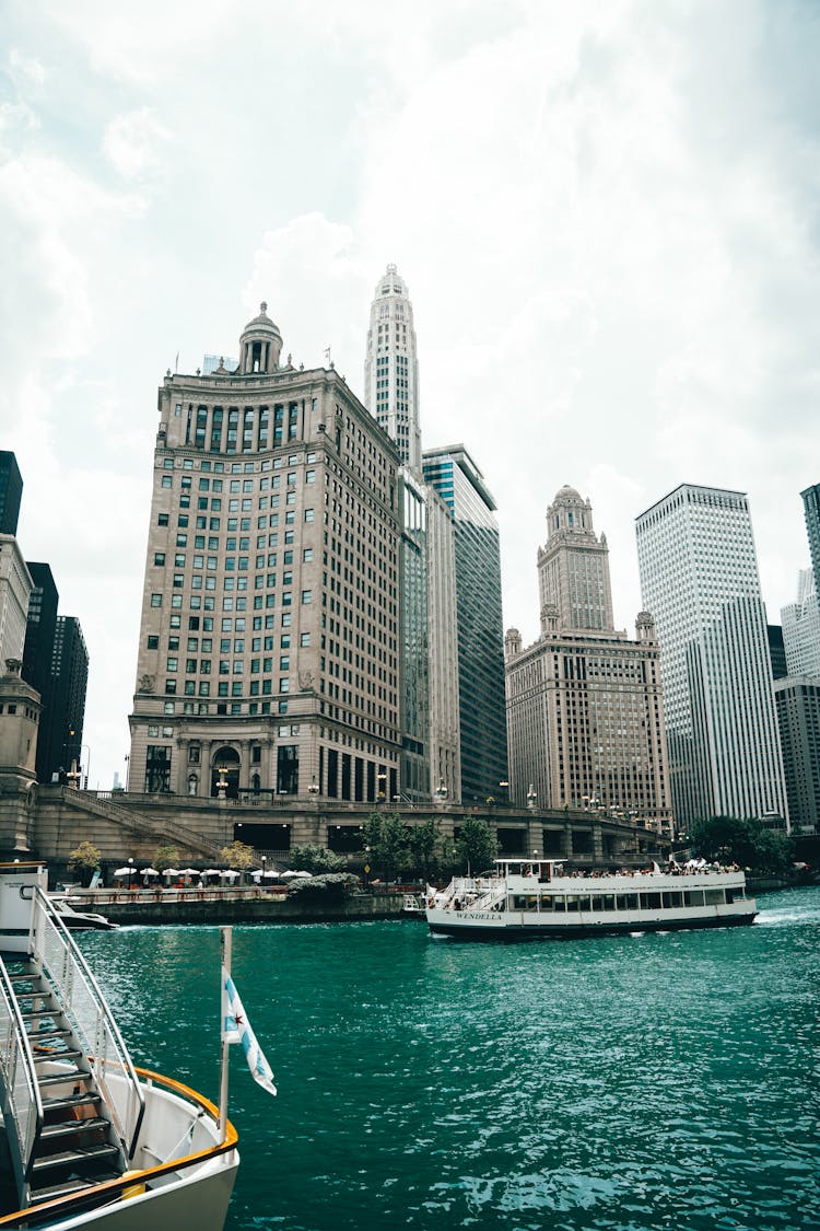 A Sailing Ferry Boat On The River Near The City Buildings In Chicago Illinois