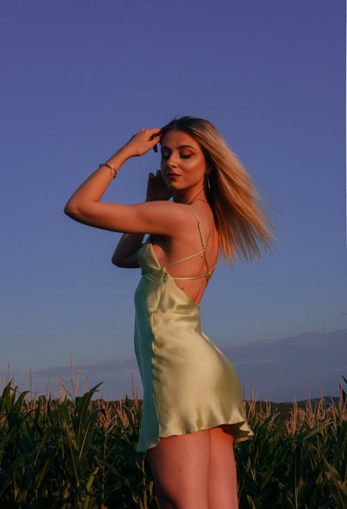 Woman in Green Spaghetti Strap Dress Standing on Corn Field