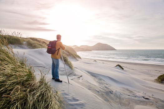 日出时分，一名孤独的徒步旅行者在海边沙丘探索，捕捉大自然的美丽