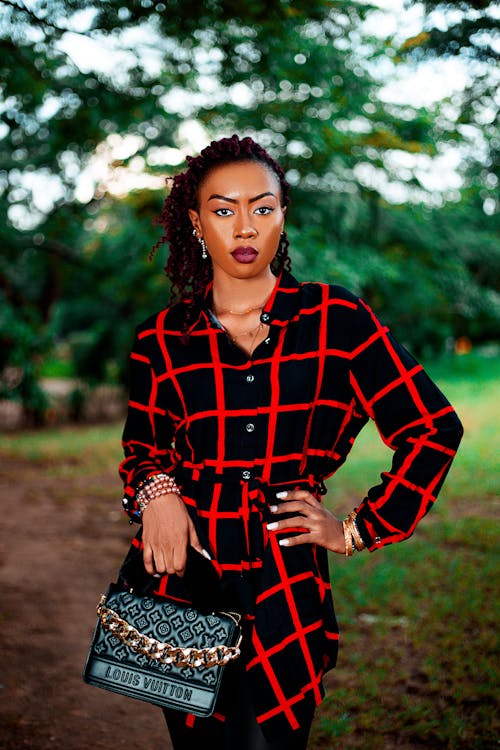 Woman with a Black Purse Posing with Her Hand on Her Waist