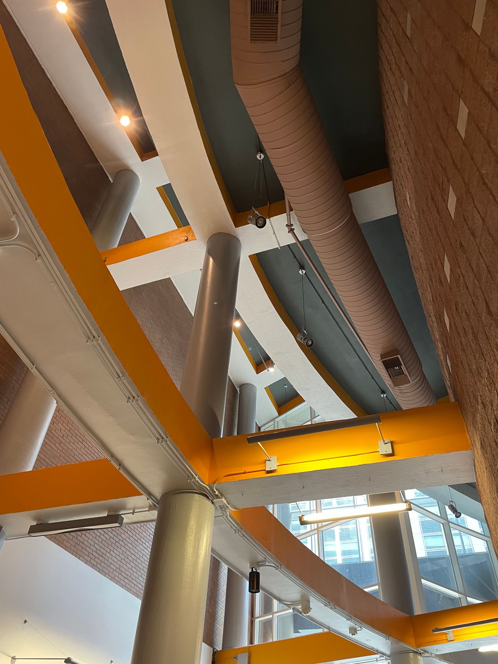 Indoor air quality testing — commercial atrium with exposed HVAC ductwork delivering ventilation per ASHRAE 62.1
