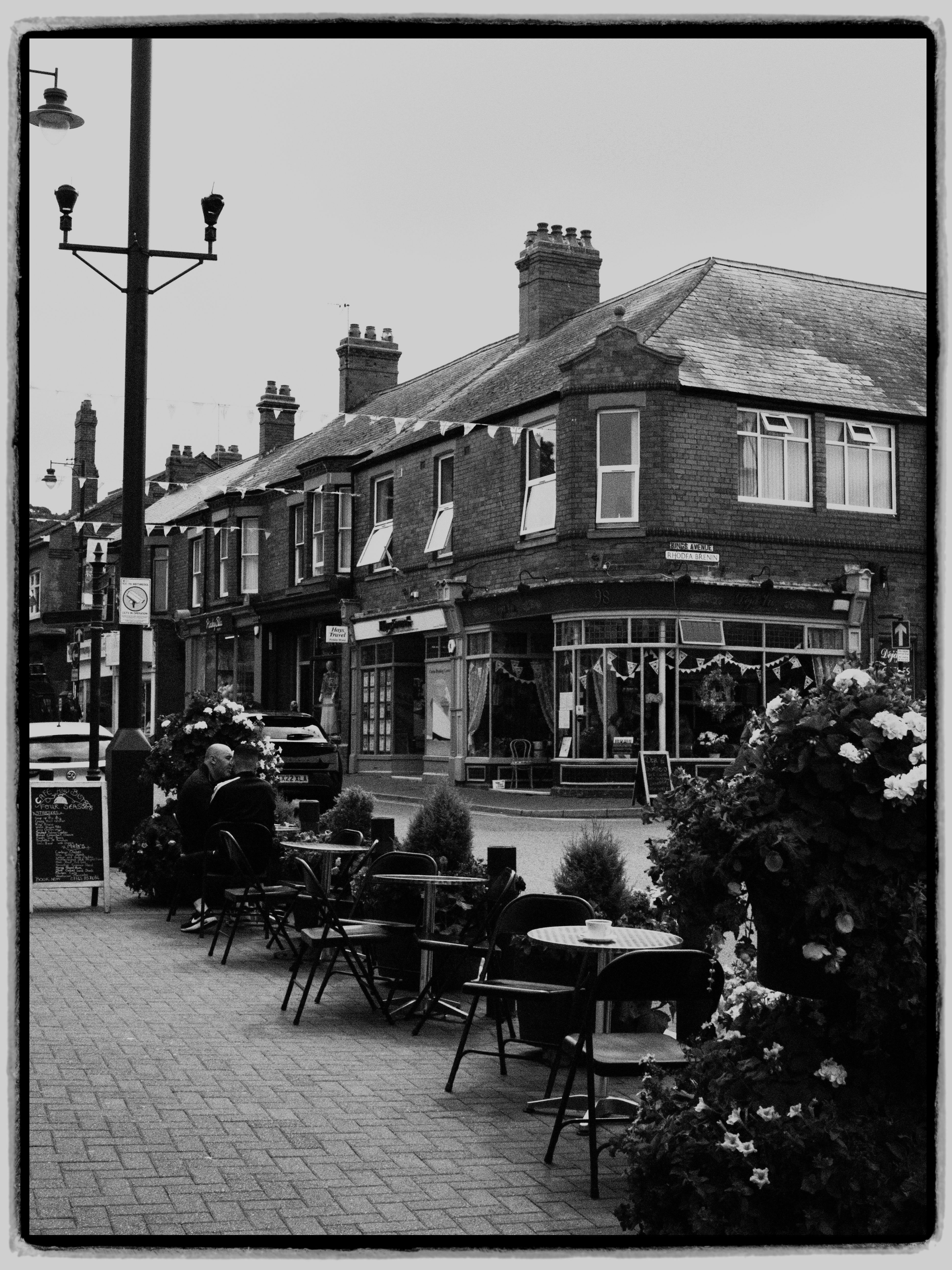 Classic black and white image of an outdoor café on a charming town street.