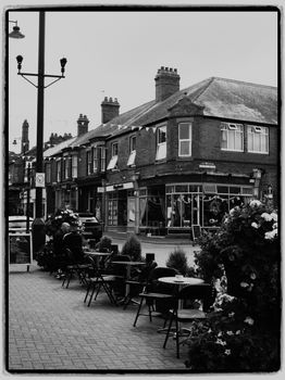 Classic black and white image of an outdoor café on a charming town street.