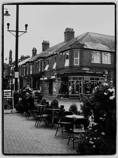 Classic black and white image of an outdoor café on a charming town street.