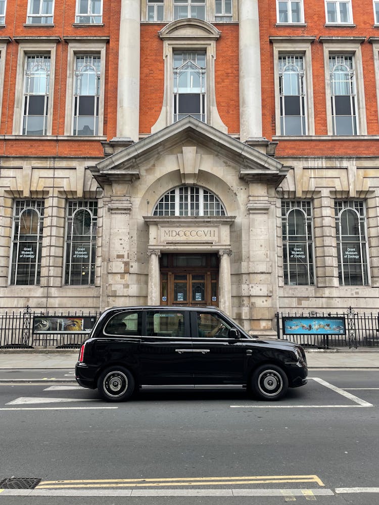 Black Car On The Road Near Concrete Building With Glass Windows