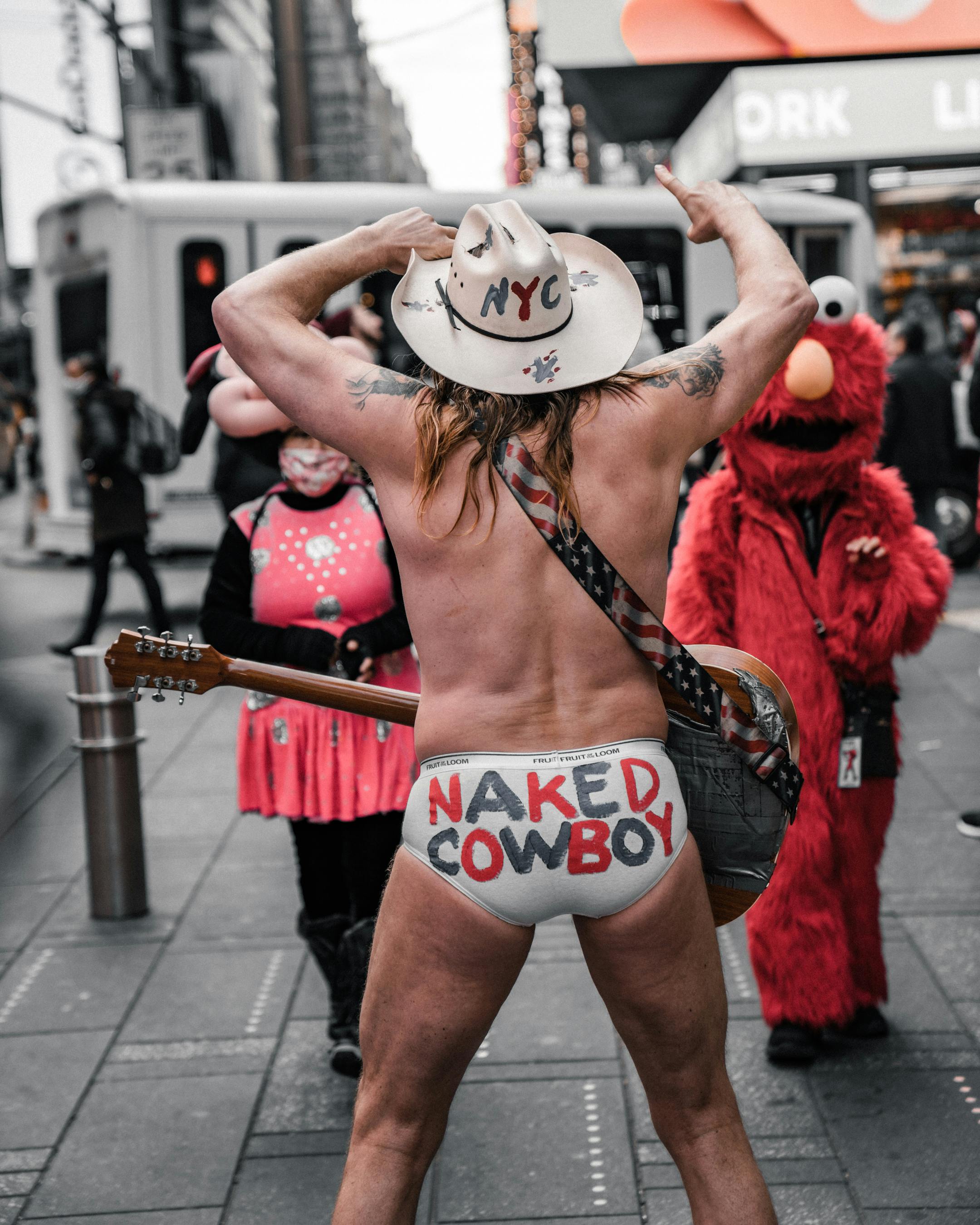 half naked cowboy standing on the street