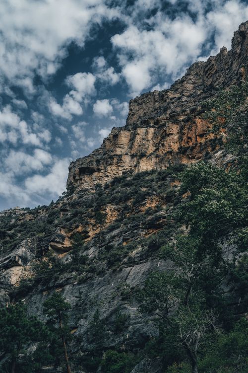 Free Capture the rugged beauty of a cliff under a dramatic, cloud-filled sky. Stock Photo
