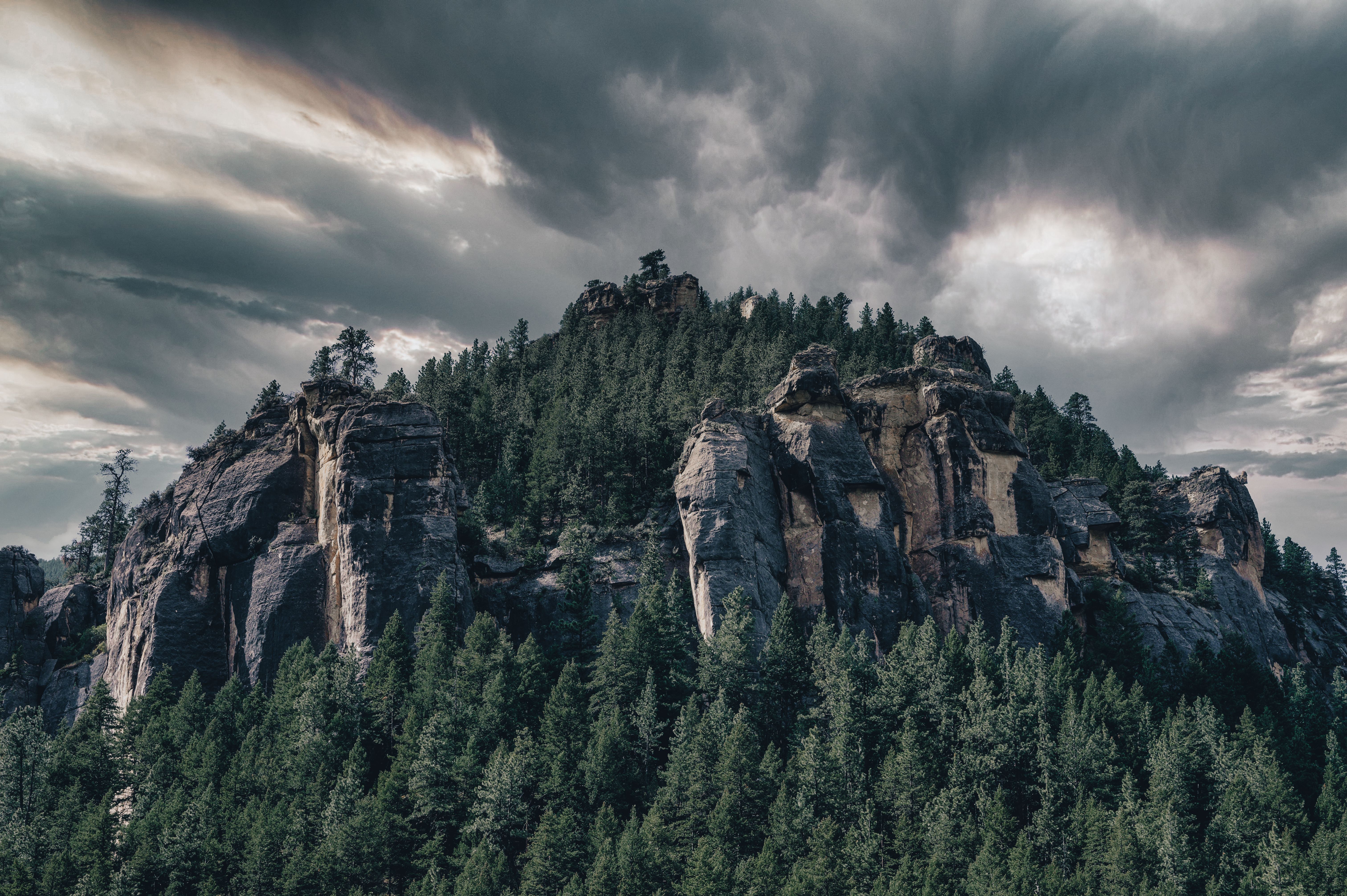 Rocky mountain formations under a dramatic cloud-filled sky