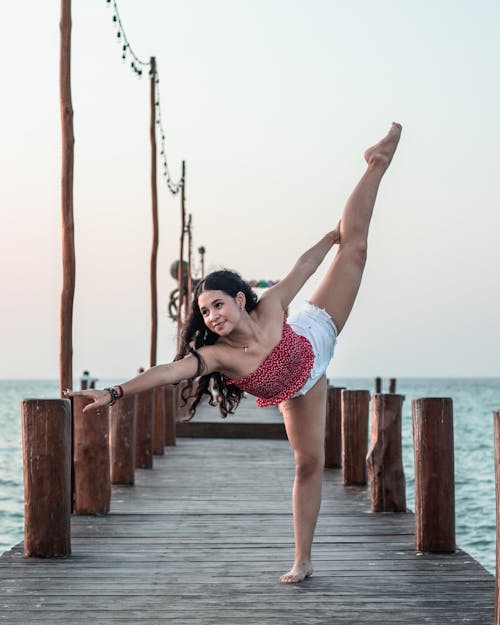 Photo of a Flexible Woman on a Pier