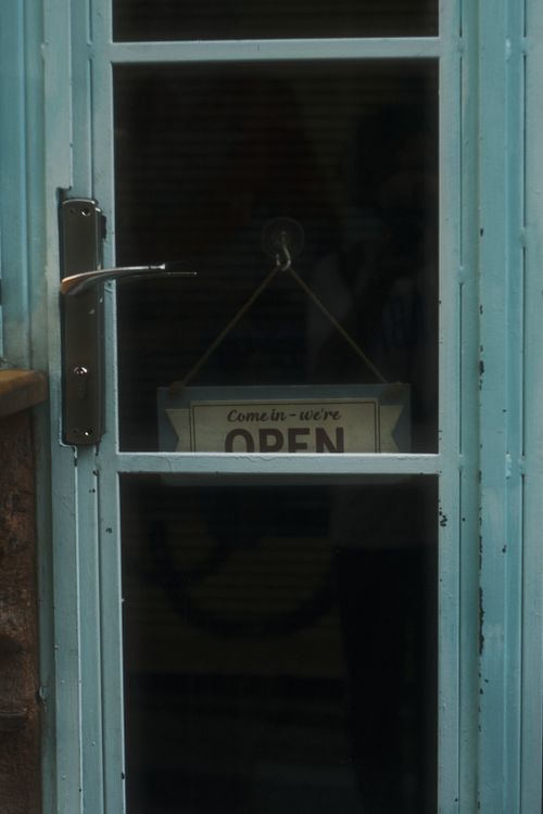 Free A glass-paneled vintage door featuring an open sign, inviting customers inside. Stock Photo