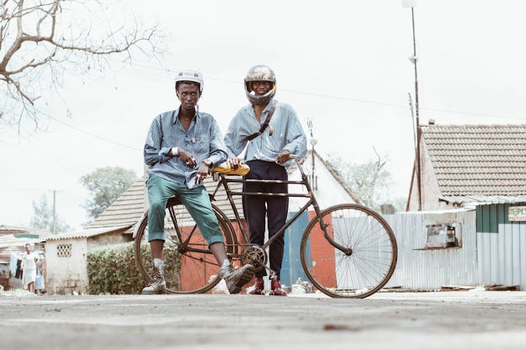 Man Wearing Helmet Holding Brown Bicycle