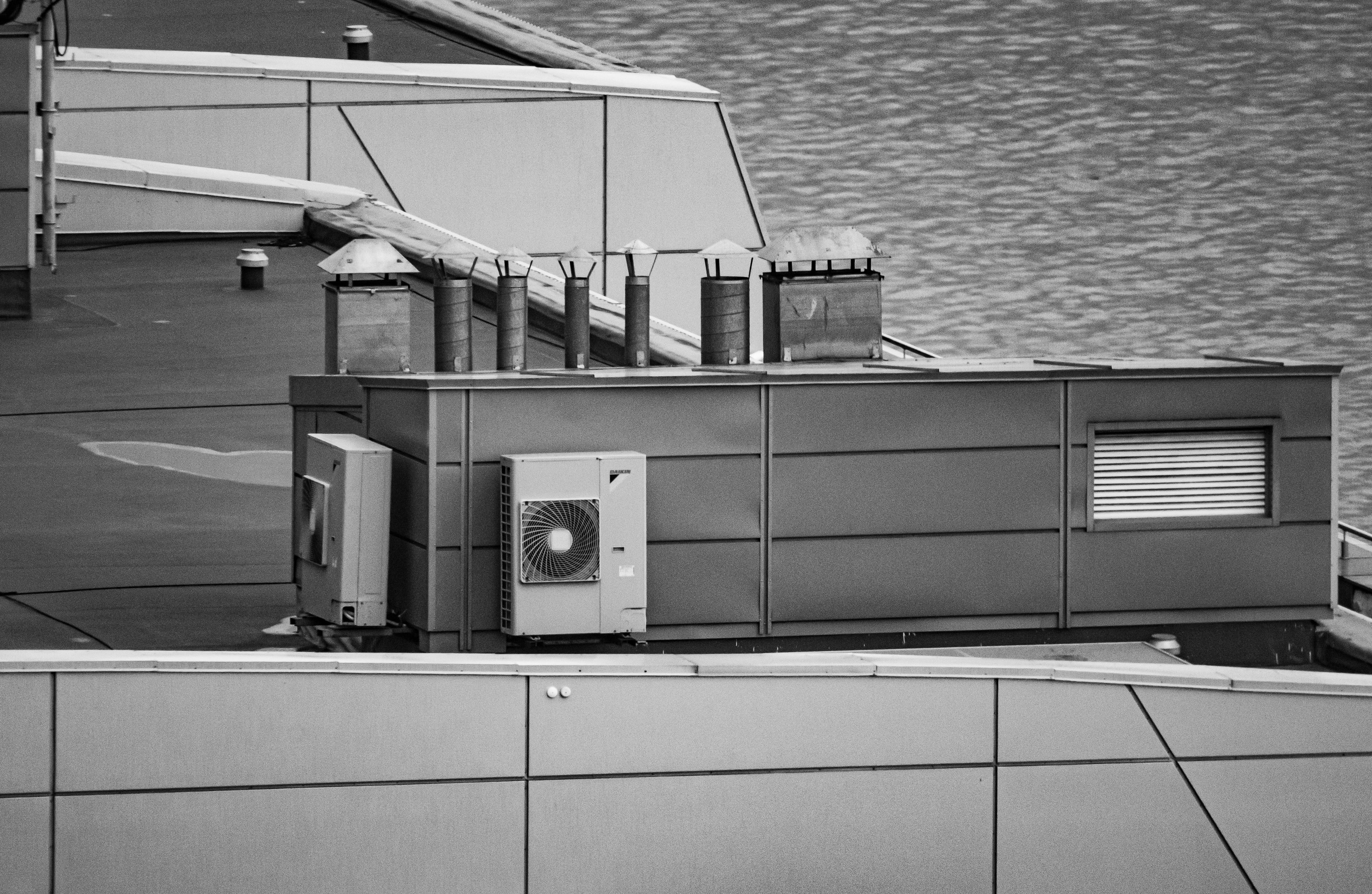 Caissons d'extraction et unités de ventilation installés en toiture-terrasse d'un bâtiment tertiaire