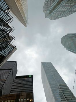 Low angle view of modern skyscrapers against a cloudy sky with architectural designs.