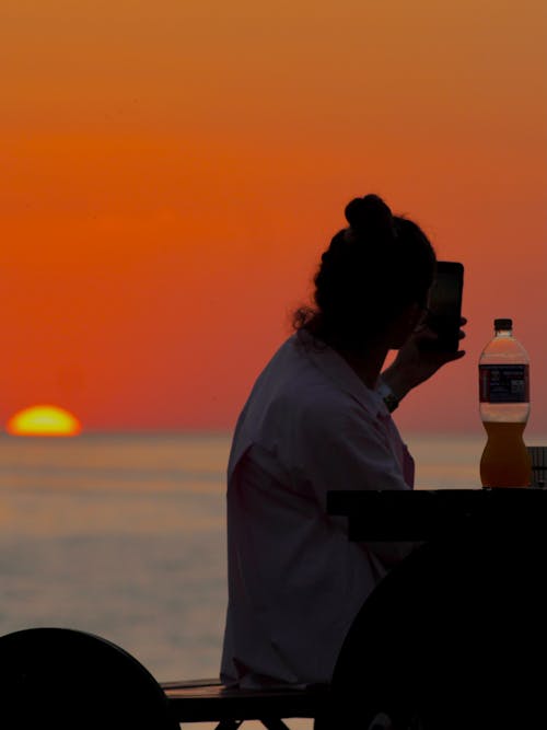 Silhouette of a Woman Taking a Picture