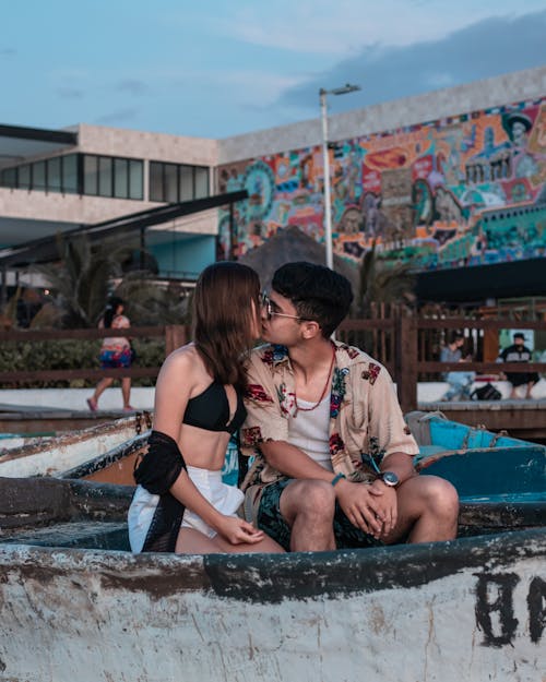 Free A Couple Kissing while Sitting on a Boat Stock Photo