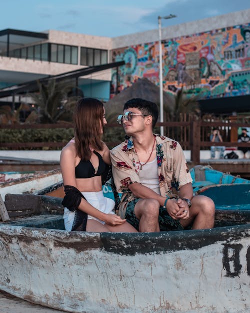 Man and a Woman Looking at Each Other while Sitting on a Boat