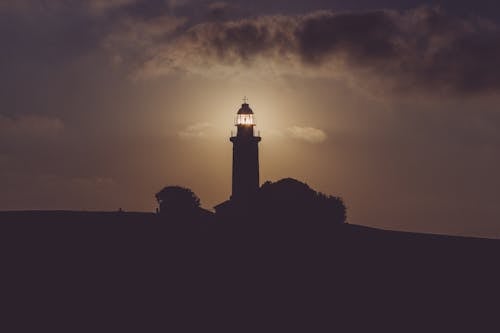 Free Silhouette of Light House Under Gray Dark Sky Stock Photo