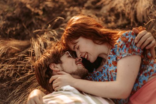 Free A young couple lovingly embracing outdoors, capturing a moment of romantic affection in nature. Stock Photo