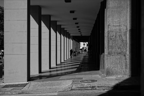 Free Black and white photo of a shaded passageway with columns in Buenos Aires, Argentina. Stock Photo