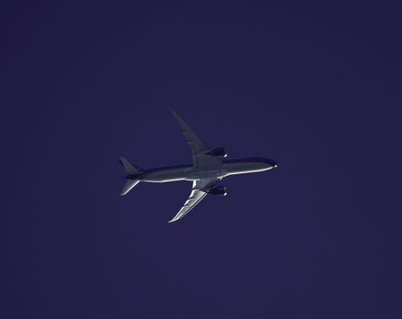 A silhouette of an airplane soaring through the twilight sky, showcasing its sleek design and powerful wings.