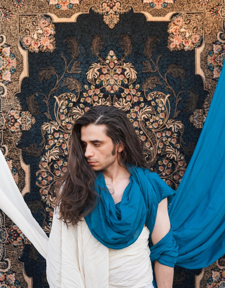 Man With Long Hair Posing On Carpet Background