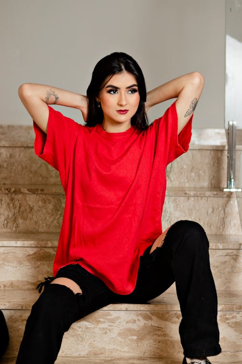 Woman in a Red Shirt Sitting on the Stairs