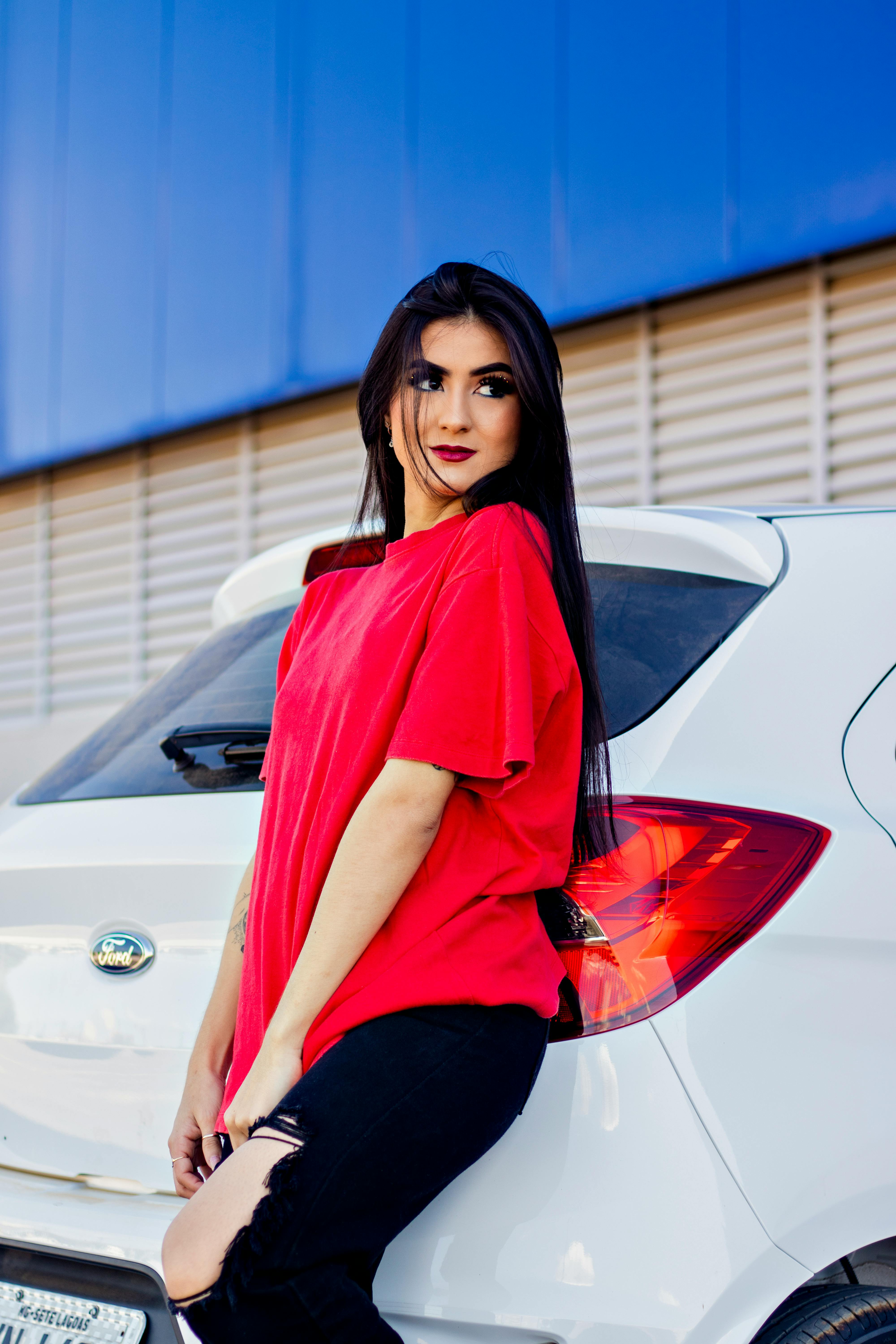 Woman in Red Sleeveless Top Posing on White Mercedes-Benz Car