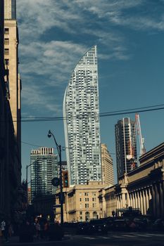 Explore the unique architectural design of the L Tower in Toronto's vibrant cityscape on a sunny day.