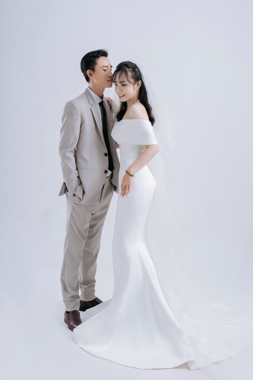 Free A stylish Asian couple poses in wedding attire for a studio shoot. Stock Photo