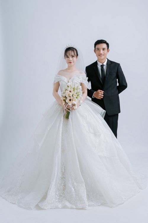Free A bride and groom pose in elegant attire, highlighting their wedding day joy. Stock Photo